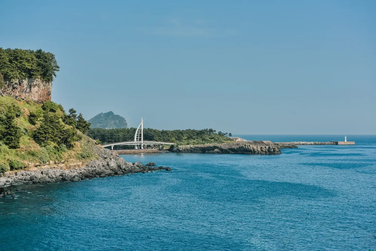 A breathtaking coastal view of Jeju Island with clear blue waters and scenic cliffs.